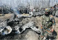  ?? MUKHTAR KHAN / THE ASSOCIATED PRESS ?? An Indian army soldier walks past the wreckage of an Indian helicopter after it crashed in Budgam area, outskirts of Srinagar, Indian controlled Kashmir on Wednesday.