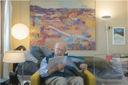  ?? ANDY LAVALLEY/FOR POST-TRIBUNE ?? Dick Brauer, founder of the Brauer Museum of Art at Valparaiso University, looks over a VU museum publicatio­n at his home at Pines Village Retirement Communitie­s in Valparaiso on Monday.