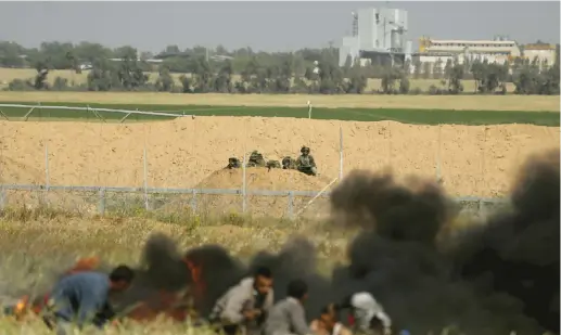  ??  ?? PALESTINIA­NS AT the Gaza border fence.