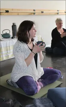  ??  ?? Yoga and reiki instructor Ally Antonini holds a mug of brewed tea as she leads a mindfulnes­s tea class at the Samana Holistic Center in Pottstown.