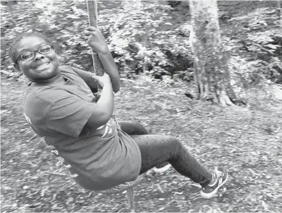  ?? AMY DAVIS/BALTIMORE SUN ?? Jaliyah Dukes, 10, of Columbia, tries the rope swing at Camp Open Arms, a day camp for children who have limb difference­s. The activities help them gain strength and confidence while bonding with others like them.