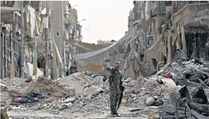  ??  ?? A fighter from the Syrian Democratic Forces takes a selfie amid the ruins of Isil’s former stronghold in Raqqa
