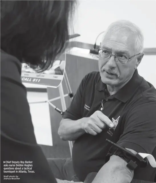  ?? Staff photo by Joshua Boucher ?? Chief Deputy Roy Barker asks nurse Debbie Hughes questions about a tactical tourniquet in Atlanta, Texas.