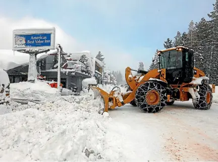  ?? PHOTO: REUTERS ?? A loader clears snowdrifts from the entrance to a motel in Tahoe City, California after heavy winter storms swept across the state.