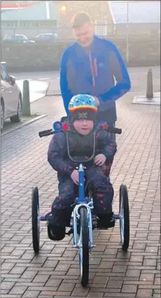  ??  ?? Greg and Cooper take the trike for a spin on Christmas morning.