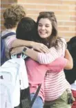  ?? STAFF PHOTO BY ERIN O. SMITH ?? Freshman Cassidy Pawson, left, hugs Camille Ward, a youth director at Signal Mountain Presbyteri­an Church, as Pawson starts the first day of school at Signal Mountain Middle/High School on Wednesday.