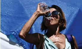  ?? Patrick T Fallon/AFP/Getty Images ?? A person drinks water in ‘the Zone’, a homeless encampment in Phoenix, Arizona. Photograph: