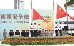  ?? PROVIDED TO CHINA DAILY ?? The nation flag and flag of the special administra­tive region are raised as a billboard saying the national security law will preserve “one country, two systems” and restore stability serves as a background.