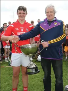  ??  ?? Fethard captain Adam O’Grady receiving the trophy from John O’Neill, Chairman of Wexford’s Coiste na nÓg.