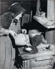  ?? SUBMITTED PHOTO ?? Mabel Wetzel, a Pennsylvan­ia Dutch woman from Lehigh County, demonstrat­es pouring waffle batter into a 19th Century waffle iron on a 19th Century Orr and Panther cast iron kitchen stove made in Reading in the post Civil War period.