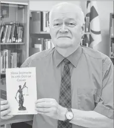  ?? ADAM MACINNIS/THE NEWS ?? Clyde Macdonald holds a copy of his latest book, Nova Scotians In and Out of Court.