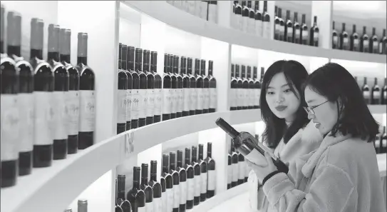  ?? LIU CHAN / XINHUA ?? Consumers choose red wine at the Chongqing Internatio­nal Exhibition and Trading Center in January.