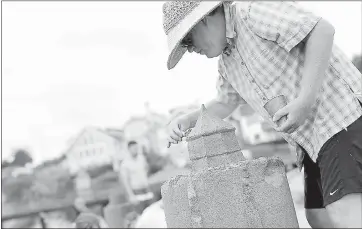  ?? STAFF FILE PHOTO ?? Chris Ridgway, who has participat­ed in the sand sculpture contest for 27years, carefully etches details into the side of a sand castle at Capitola Beach, where hundreds celebrated the opening day of the Begonia Festival.