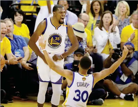  ?? ASSOCIATED PRESS ?? GOLDEN STATE WARRIORS FORWARD KEVIN DURANT (35) celebrates with guard Stephen Curry (30) Sunday during the second half of Game 2 of the NBA Finals against the Cleveland Cavaliers in Oakland, Calif. The Warriors won, 132-113.