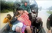  ?? JOE RAEDLE/GETTY ?? An airboat is used Monday to transport children to safety as rain from Harvey continued to overwhelm Houston.