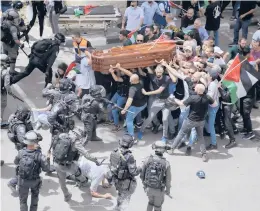  ?? MAYA LEVIN/AP ?? Israeli police confront mourners as they carry the casket of slain Al Jazeera veteran journalist Shireen Abu Akleh during her funeral Friday in east Jerusalem.