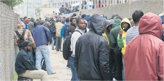 ?? Picture: AFP ?? FRUSTRATIN­G. Hundreds of refugees, mostly from other African countries, queue outside the South African department of home affairs, on the UN’s World Refugee Day in 2013, to apply for extensions of their asylum seeker permits, and other similar documents, in the centre of Cape Town. Some of these refugees voiced their frustratio­n at the very slow pace at which home affairs was able to process their requests, meaning people queued from very early in the morning until evening, sometimes for up to two weeks to get their paperwork done.