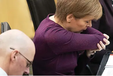  ??  ?? Stressful: Nicola Sturgeon stifling a cough yesterday, alongside John Swinney