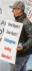  ?? Foto: P. Kneffel, dpa ?? Ein Mann, der eine Neuwahl des Land‰ tags erreichen will, auf dem Weg zu ei‰ ner Demo in München.