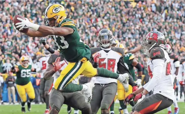  ?? ADAM WESLEY / USA TODAY NETWORK-WISCONSIN ?? Green Bay Packers running back Aaron Jones dives into the end zone to score the winning touchdown against the Tampa Bay Buccaneers in overtime Sunday at Lambeau Field. Jones scored on a 20-yard run on his only carry of the game.