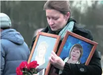  ?? AP Photo ?? A woman holds portraits of Irina Medyantsev­a, one of the metro blast victims, during her funeral near St Petersburg yesterday.