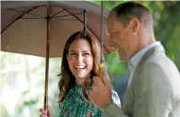  ?? AP ?? Prince William and his wife Kate, Duchess of Cambridge smile as they walk through the memorial garden in Kensington Palace, London, last week. —