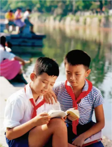  ??  ?? This 1972 photo shows two students reading a comic book by a river in Guilin, Guangxi huang Autonomous Zegion. by i MINGͬCFB