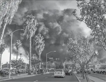  ?? Photograph­s by Irfan Khan Los Angeles Times ?? A THREE-ALARM FIRE at an Ontario waste recycling facility produced an enormous black plume of smoke, knocked out power to nearby homes and businesses, and forced about 200 residents to evacuate.