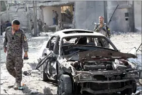  ??  ?? A member of Afghan security forces looks at a damaged car at the site of yesterday’s night-time car bomb blast in Kabul, Afghanista­n on Wednesday.reuters/stringer