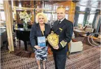  ??  ?? Councillor Maxine Smith hands over a plague to captain Rudenko Andrey of the Hebridean Sky