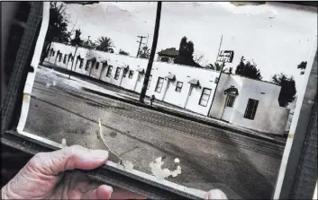  ?? BRIAN VAN DER BRUG/LOS ANGELES TIMES/TNS ?? Lily Ho, 78, holds a vintage photo of the Hayes Motel in Los Angeles. Her family has owned the motel for nearly 40 years, and it was listed in the Green Book, a travel guide for African-Americans using Route 66.