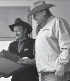  ?? Photos by Matthew Liebenberg ?? Bryce Burnett (at left) makes a presentati­on to Uli Cartman, who served as a director from 2012- 2018 and chaired the Frontier Days CCA Rodeo committee during this period.