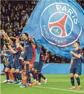  ??  ?? Paris Saint-Germain players celebrate winning Ligue 1 at the Parc des Princes in Paris on Sunday. REUTERS PIC