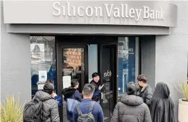  ?? Justin Sullivan/Getty ?? A worker, middle, tells customers Silicon Valley Bank headquarte­rs is closed, March 10, in Santa Clara, California. The Justice Department and the Securities and Exchange Commission are investigat­ing the collapse of Silicon Valley Bank.