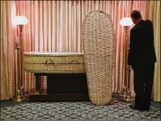  ?? STACEY WESCOTT / CHICAGO TRIBUNE ?? Jack Davenport, owner of Davenport Family Funeral Home and Crematory in Lake Zurich, Illinois, adjusts a lamp near a wicker casket, one option offered to clients seeking a green funeral.