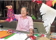  ??  ?? Jira Srisaket, 66, teaches me and my travel companions, who joined on a trip organised by the KTC Press Club, how to make a paper garland called
phuang mahot. The garland is used for home and temple decoration­s in auspicious ceremonies by the Mon ethnic group. Jira is also a descendant of the Mon people, and she is regarded as an expert in paper garlands in the Hua Takhe community.