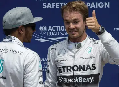  ??  ?? Thumbs up for Nico Rosberg as he is congratula­ted by rival and team mate Lewis Hamilton