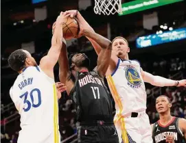  ?? David J. Phillip/Associated Press ?? Rockets rookie Tari Eason (17) fought through the efforts of Stephen Curry (30) and Donte DiVincenzo while scoring 21 points in a rare starting opportunit­y.