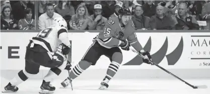  ?? — AFP ?? CHICAGO: Artem Anisimov #15 of the Chicago Blackhawks turns to pass against Nikita Nesterov #89 of the Tampa Bay Lightning at the United Center on Tuesday in Chicago, Illinois. The Lightning defeated the Blackhawks 5-2.