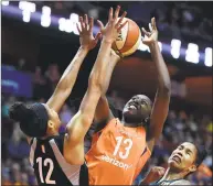  ?? Sean D. Elliot / Associated Press ?? Connecticu­t Sun forward Chiney Ogwumike (13) draws the foul on the Las Vegas Aces’ Nia Coffey (12) as Tamara Young, right, helps on defense in a May 20 game at Mohegan Sun Arena.