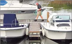  ?? Christian Abraham / Hearst Connecticu­t Media ?? Mark Smith cleans and secures his boat Friday in anticipati­on of Hurricane Henri at Halloween Yacht Club in Stamford.