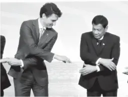  ??  ?? REACHING OUT — Canadian Prime Minister Justin Trudeau and President Duterte reach for each other’s hands for the photo session with Associatio­n of Southeast Asian Nations (ASEAN) leaders at the start of the ASEAN-Canada Summit yesterday at the...