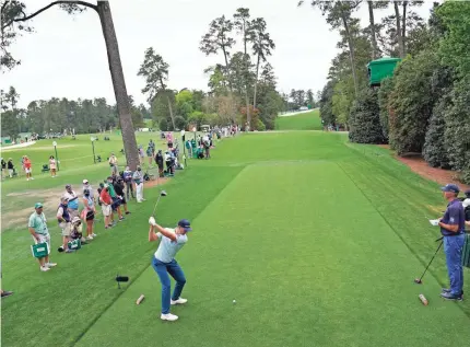  ?? MICHAEL MADRID/USA TODAY SPORTS ?? Justin Rose hits his tee shot on the 18th hole Thursday and finished his first round with a 7-under 65 and the lead in the Masters.