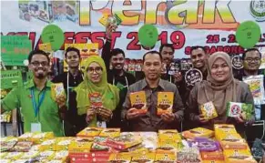  ?? (Foto Balqis Jazimah Zahari/bh) ?? Abdul Yunus (dua dari kanan) menunjukka­n produk ikan pekasam yang dijual sempena Malaysia Fest 2019 di Singapura, baru-baru ini.