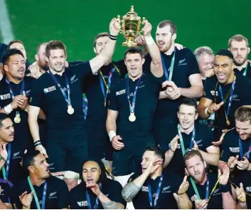  ?? GETTY ?? Richie McCaw, 34 anni, a sinistra, e Dan Carter, 33 anni, sollevano la Coppa circondati dalla marea nera degli All Blacks