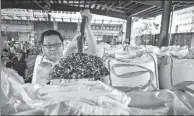  ?? MAO SIQIAN / XINHUA ?? A worker for Shenzhen Customs in Guangdong province shows the plastic waste that was seized in June last year.