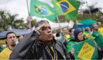  ?? MATIAS DELACROIX/AP ?? A supporter of Brazilian President Jair Bolsonaro salutes earlier this month in São Paulo, Brazil.