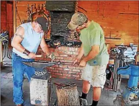  ?? JOHN BREWER — ONEIDA DAILY DISPATCH ?? Blacksmith Mike Allen, left, works with one with one of his pupils on the anvil at the Chittenang­o Landing Canal Boat Museum in 2016. Allen will hold blacksmith­ing demonstrat­ions throughout July and August at the CLCBM.