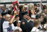  ?? THE ASSOCIATED PRESS ?? Mourners hold photos of their loved one during the 15th anniversar­y of the attacks of the World Trade Center at the National September 11 Memorial on Sunday in New York.