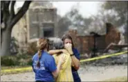  ?? MARCIO JOSE SANCHEZ - THE ASSOCIATED PRESS ?? A resident, in yellow, wishing not to be identified, is comforted after seeing her fire-ravaged home for the first time Thursday, Aug. 2, in Redding, Calif.